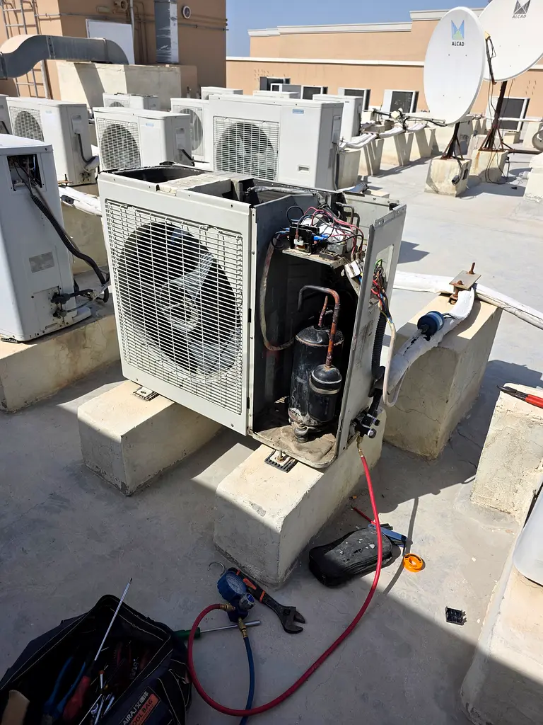 Expert technician troubleshooting a localized central ducted split unit in Al Badi'ah Riyadh